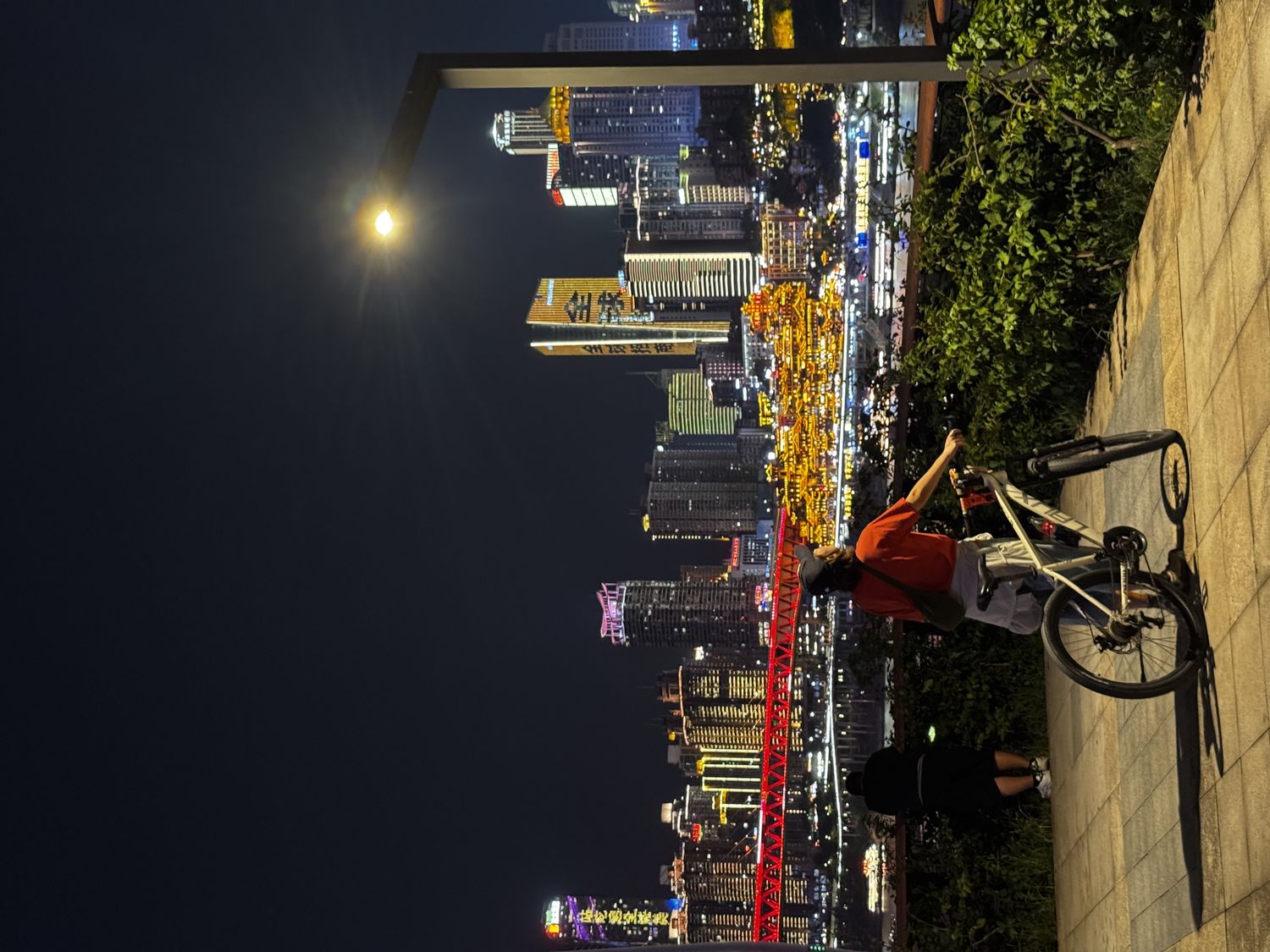 Cyclist and night skyline above the river